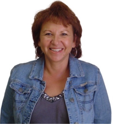 Headshot of MNA board member Angie Main, wearing a denim jacket and smiling.